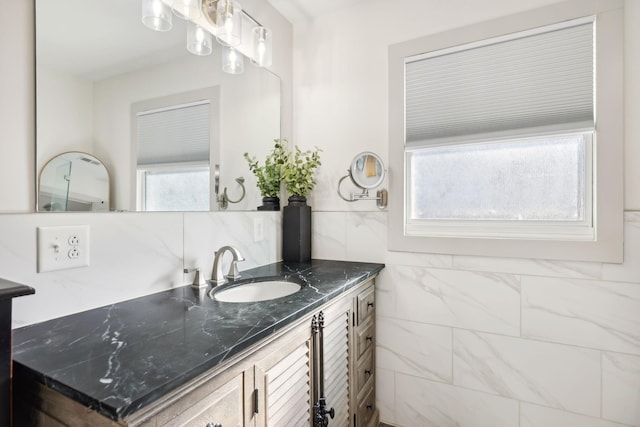 bathroom with plenty of natural light, vanity, and tile walls