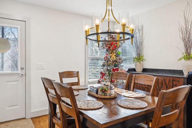 dining area featuring light wood-type flooring, an inviting chandelier, and plenty of natural light