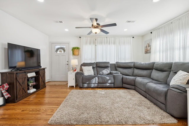 living room with light hardwood / wood-style floors, a wealth of natural light, and ceiling fan