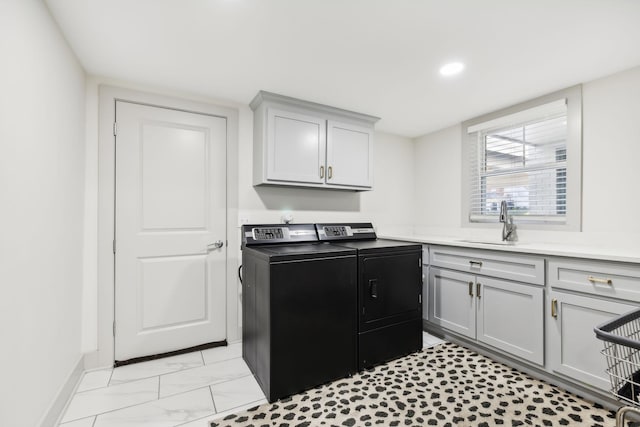 laundry area featuring washer and dryer, cabinets, and sink