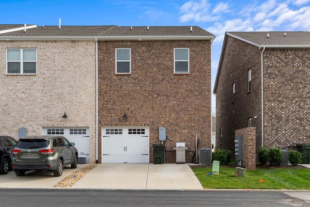 back of property featuring cooling unit and a garage