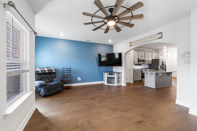 living room with ceiling fan, sink, and dark hardwood / wood-style floors