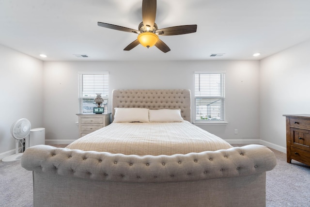 bedroom with light colored carpet, multiple windows, and ceiling fan