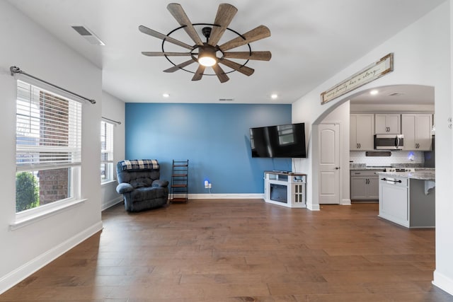 living area featuring dark hardwood / wood-style floors and ceiling fan