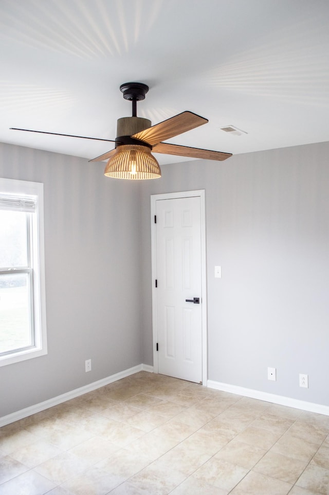 tiled empty room featuring ceiling fan