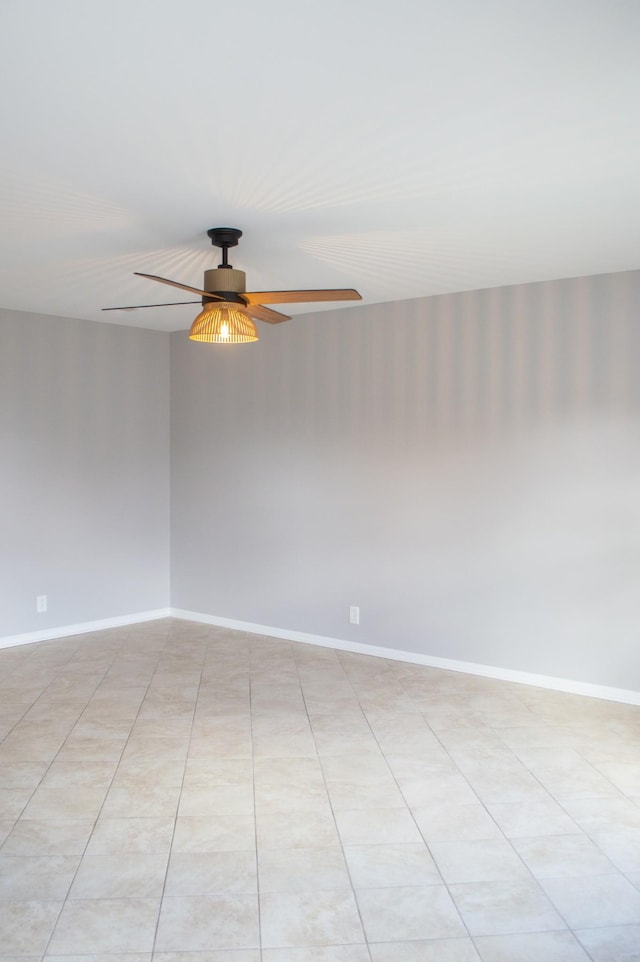 tiled spare room featuring ceiling fan