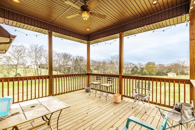 deck with a lawn and ceiling fan