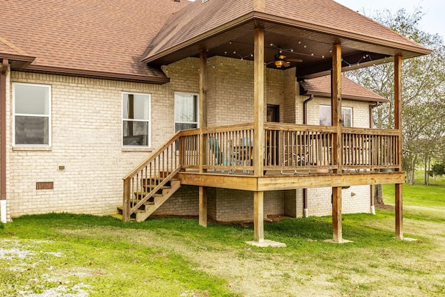 back of property with ceiling fan, a deck, and a lawn