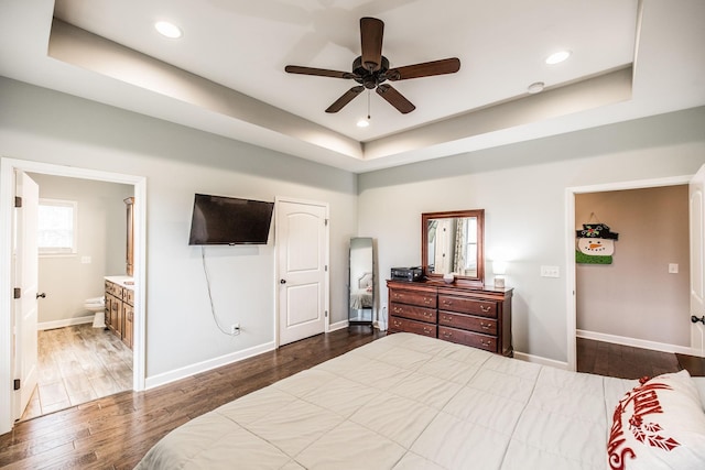 bedroom featuring dark wood-type flooring, ceiling fan, and a raised ceiling