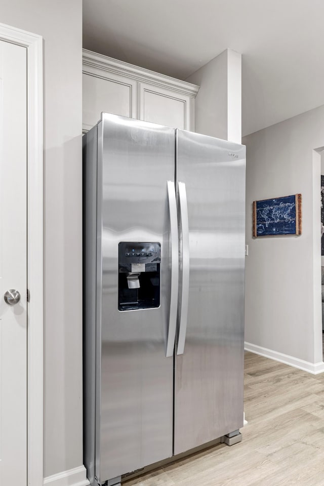 kitchen with stainless steel fridge with ice dispenser and light hardwood / wood-style floors