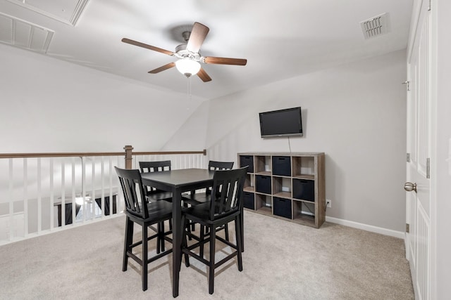 dining space with light carpet, ceiling fan, and vaulted ceiling