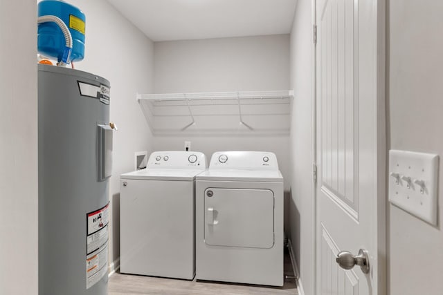 washroom with washer and clothes dryer, light wood-type flooring, and electric water heater