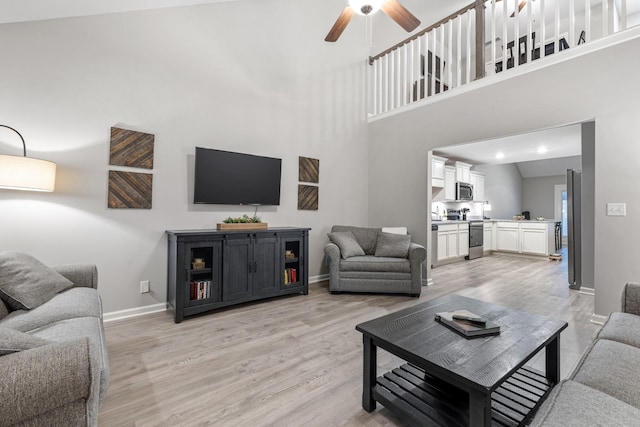 living room with high vaulted ceiling, light hardwood / wood-style flooring, and ceiling fan