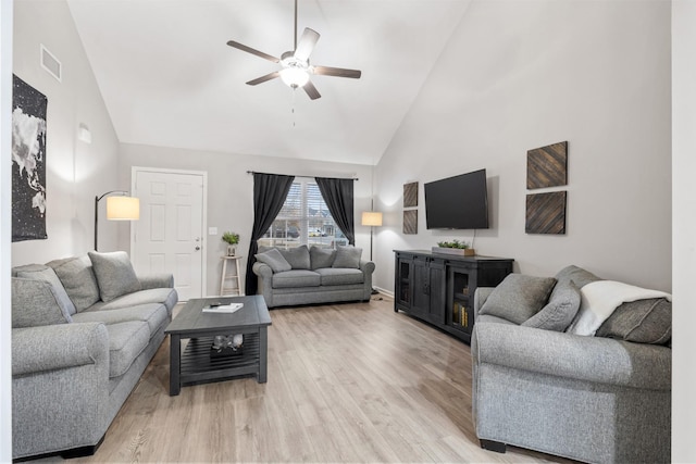 living room with ceiling fan, high vaulted ceiling, and light hardwood / wood-style floors