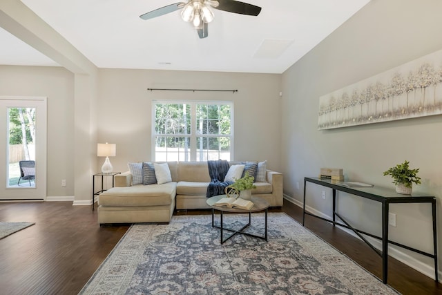 living room with ceiling fan and dark wood-type flooring