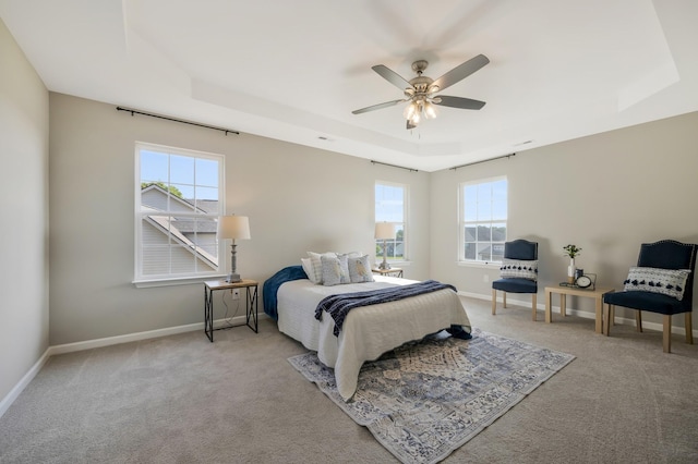 bedroom featuring a tray ceiling, ceiling fan, and light colored carpet