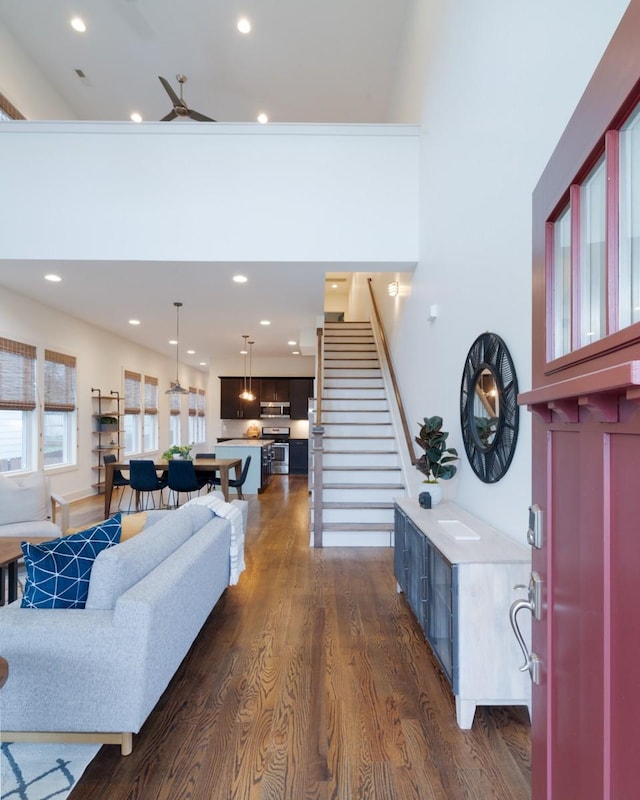 living room featuring ceiling fan and dark wood-type flooring