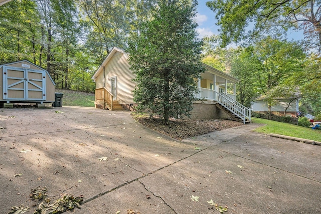 view of home's exterior with a porch and a shed