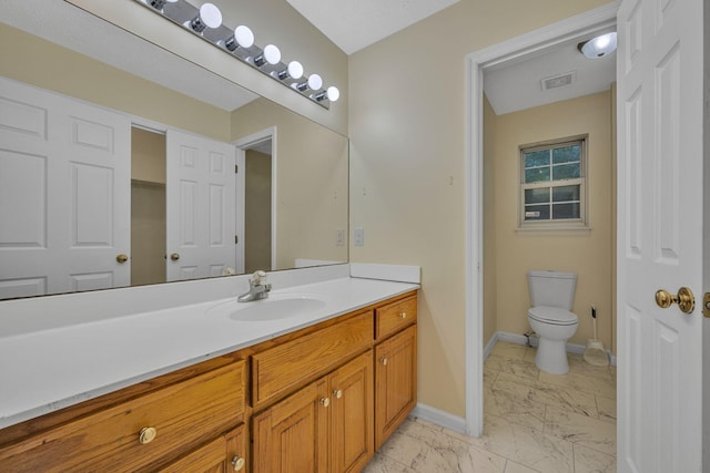 bathroom featuring a textured ceiling, vanity, and toilet