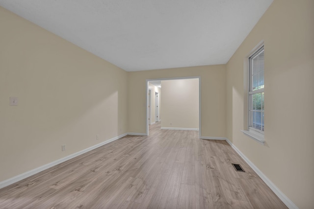 empty room with light hardwood / wood-style flooring