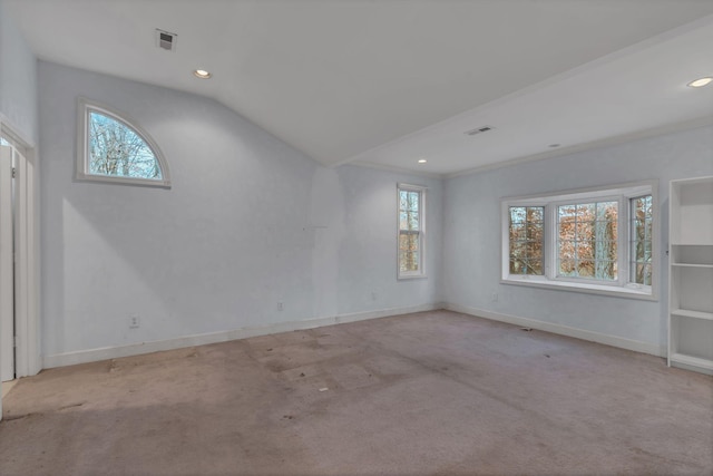 carpeted empty room featuring ornamental molding, plenty of natural light, and lofted ceiling