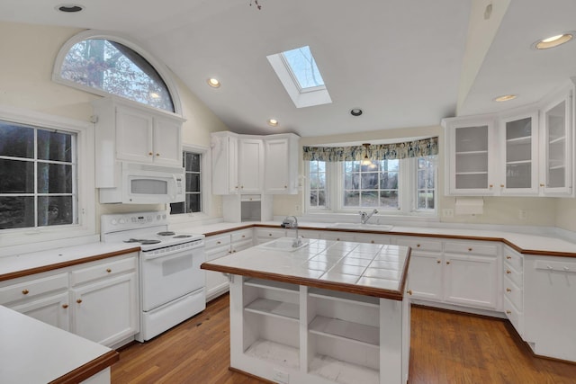 kitchen with white cabinets, wood-type flooring, white appliances, and tile countertops