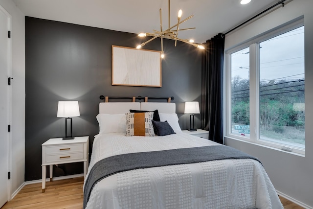 bedroom featuring light wood-type flooring and a chandelier