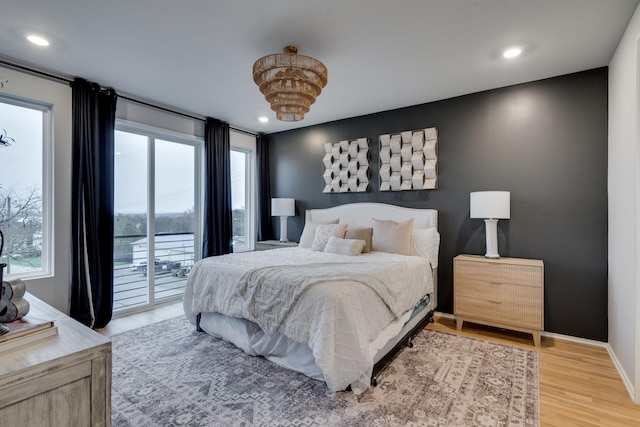 bedroom with wood-type flooring and access to outside