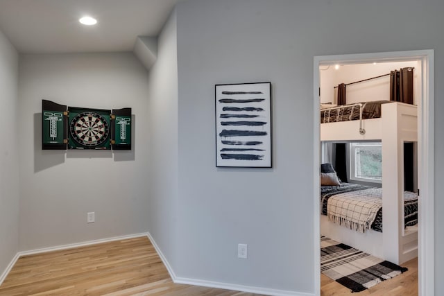 corridor with hardwood / wood-style floors and lofted ceiling