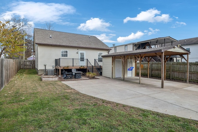 back of house with a deck, central AC unit, and a lawn