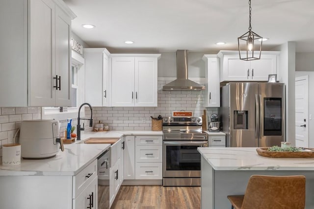 kitchen featuring sink, white cabinets, stainless steel appliances, and wall chimney range hood