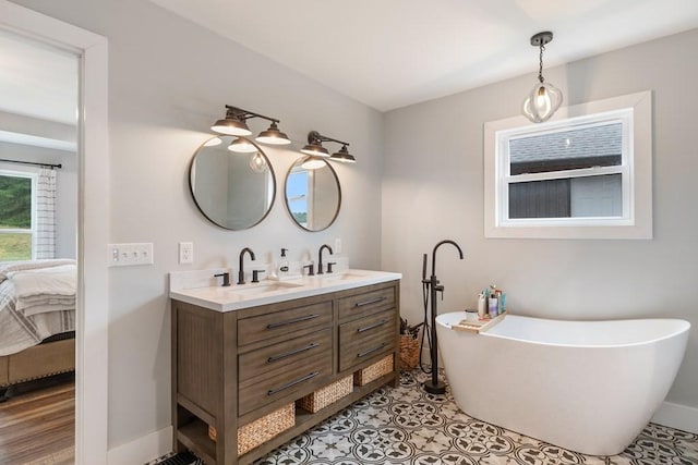 bathroom with tile patterned flooring, vanity, and a bath