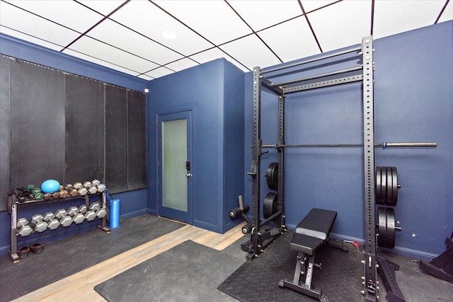 workout room featuring a paneled ceiling and hardwood / wood-style flooring