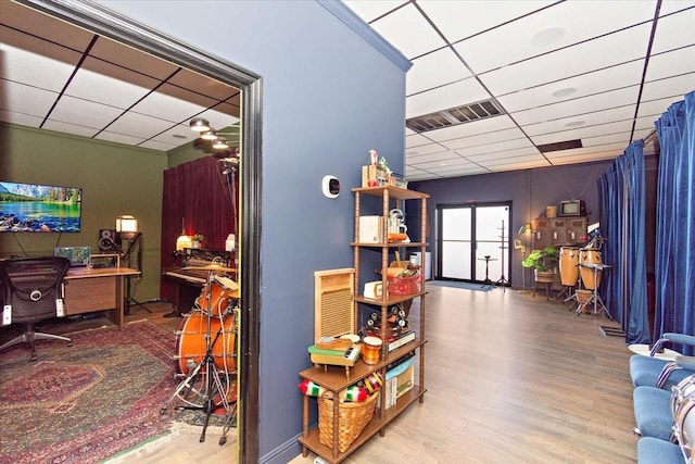 playroom featuring a paneled ceiling and light wood-type flooring