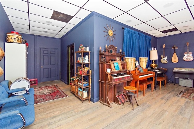 misc room with a paneled ceiling and light hardwood / wood-style flooring