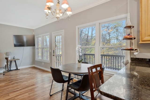 dining room featuring light wood-type flooring, ornamental molding, and a chandelier