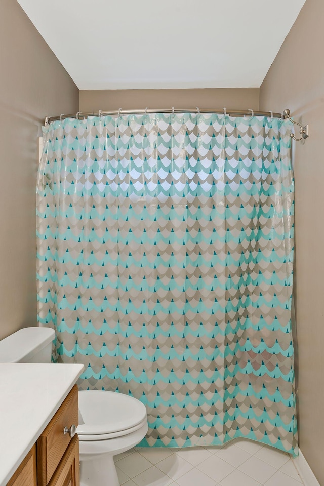 bathroom with tile patterned floors, curtained shower, vanity, and toilet