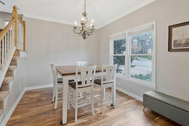 dining room with crown molding, a chandelier, and hardwood / wood-style flooring