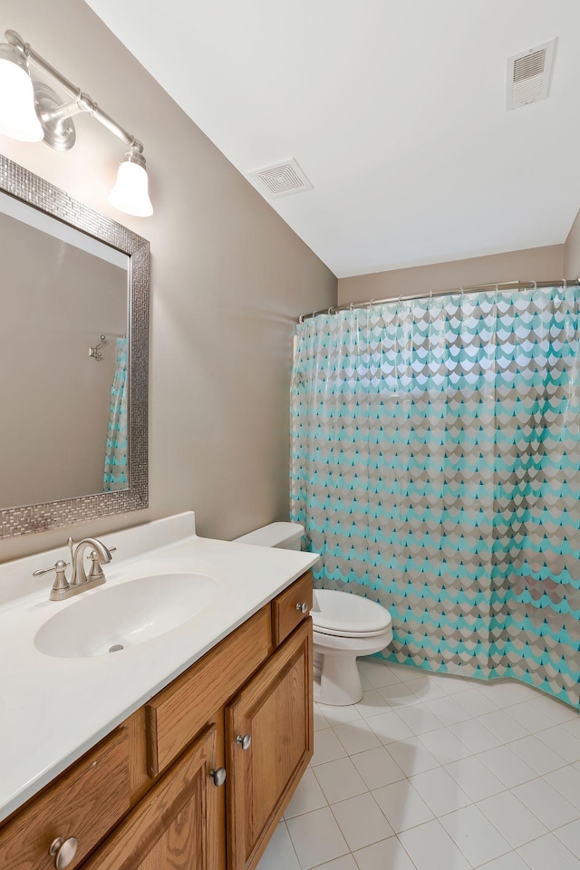 bathroom featuring toilet, vanity, tile patterned floors, and walk in shower