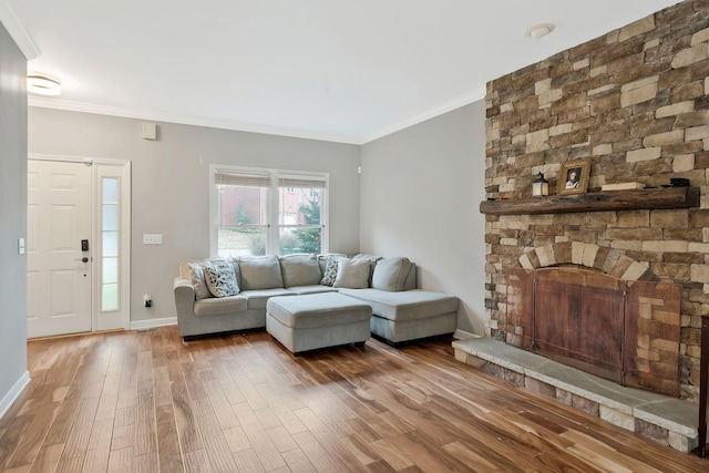 living room featuring crown molding, a fireplace, and hardwood / wood-style flooring