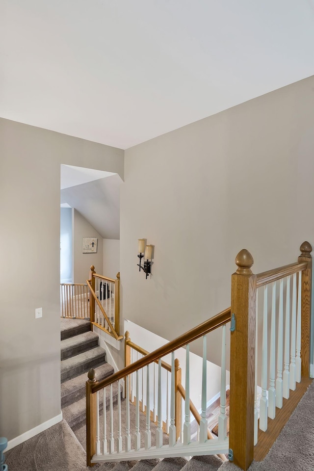 stairway with carpet floors and vaulted ceiling