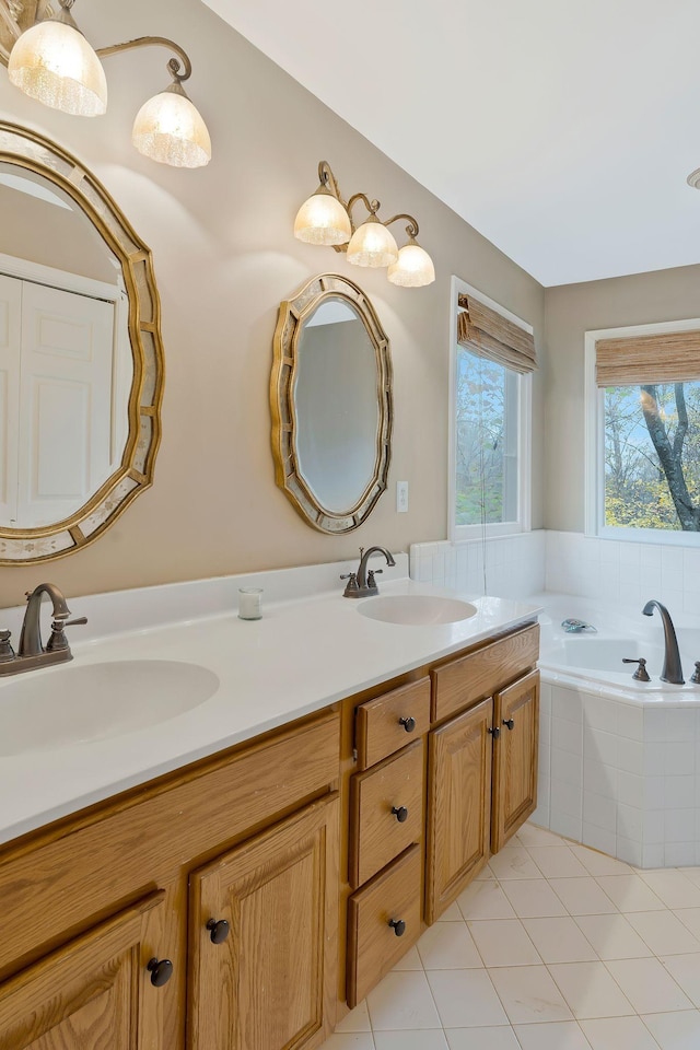 bathroom featuring tile patterned floors, vanity, and a relaxing tiled tub