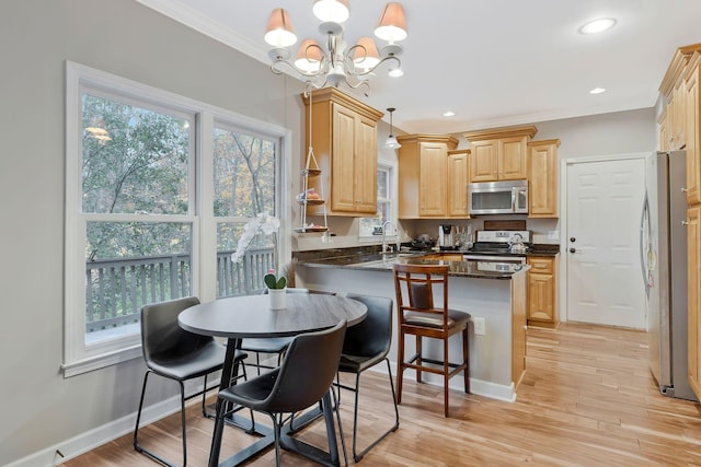 kitchen with an inviting chandelier, light hardwood / wood-style flooring, kitchen peninsula, decorative light fixtures, and appliances with stainless steel finishes