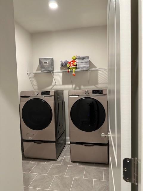 laundry area featuring laundry area, washing machine and dryer, and light tile patterned floors