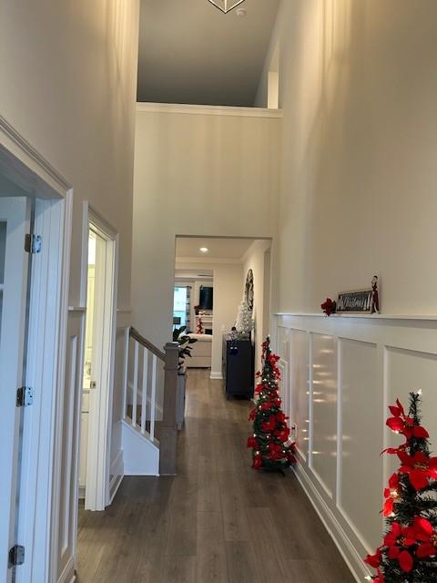 hallway with dark wood-type flooring and a high ceiling