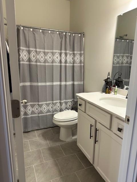 full bathroom featuring curtained shower, vanity, and toilet