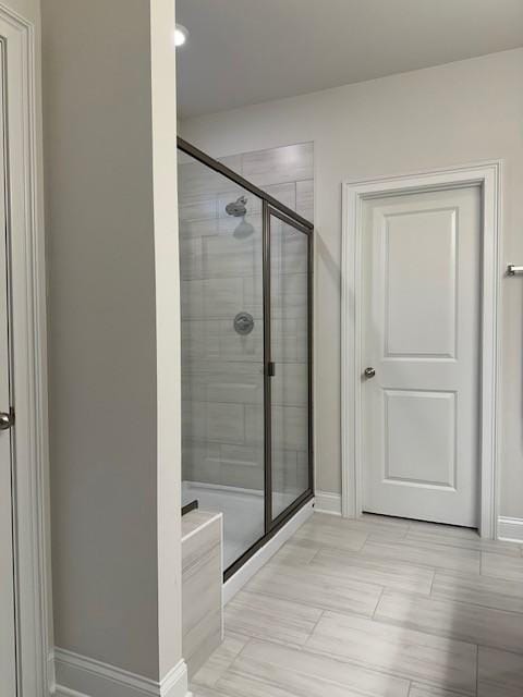 bathroom featuring a stall shower and baseboards