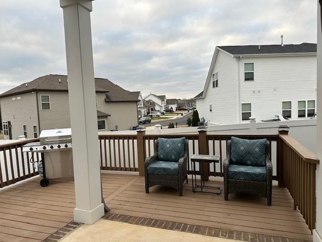 wooden terrace featuring grilling area and a residential view