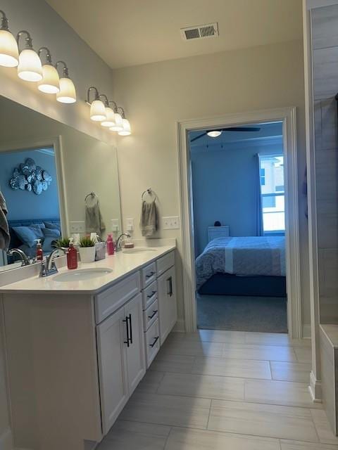 full bath featuring ensuite bathroom, double vanity, a sink, and visible vents