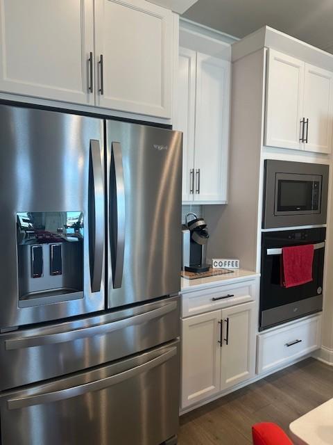 kitchen featuring white cabinets, dark wood-style floors, stainless steel appliances, and light countertops